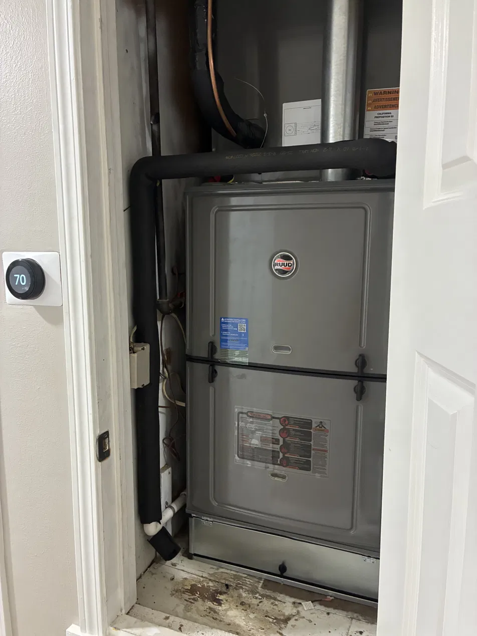 Ruud gas furnace installed in a closet with a Nest thermostat nearby in Shreveport, Louisiana