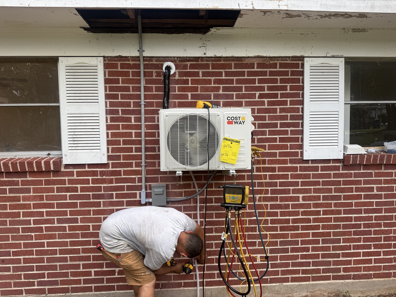 Morgan Repair technician installing a Costway ductless mini-split outdoor unit on a brick home in Shreveport, Louisiana